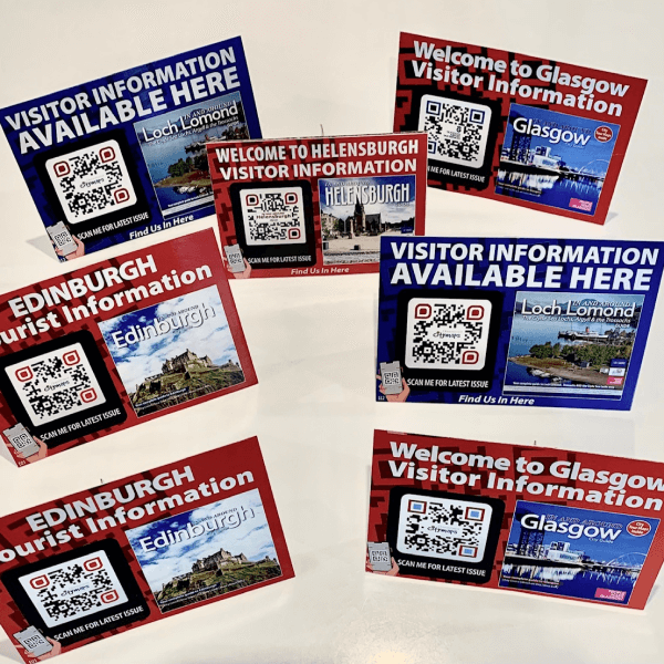  QR Codes nos displays de mesa convidando turistas a escanear o código para ler as últimas informações.