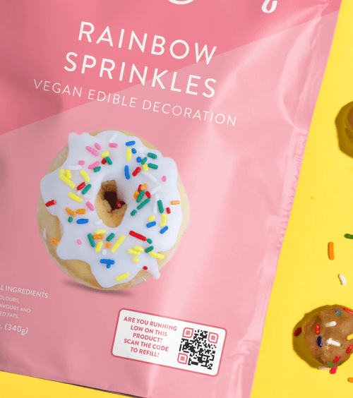 Um pacote de doce com a imagem de um donut coberto de granulado e um QR Code.