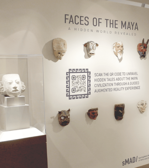QR Code numa parede com exposições artísticas divulgando um aplicativo