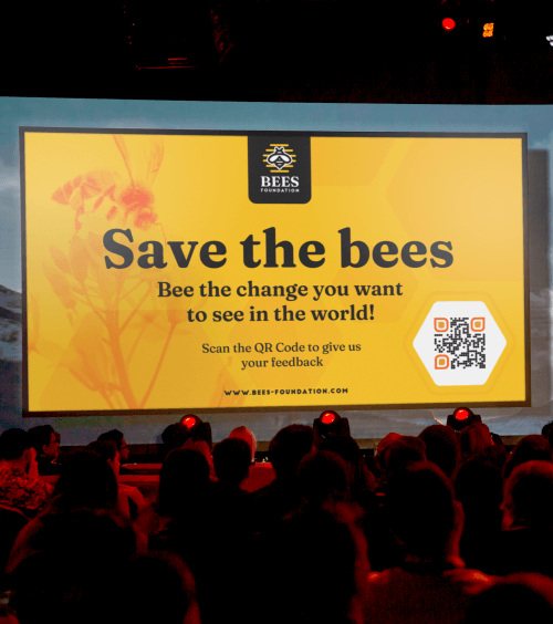 Um projetor mostrando a apresentação de uma ONG com um QR Code que redireciona os usuários a um formulário de feedback online.