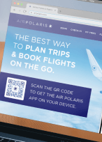 QR Code on an airline's website homepage prompting people to scan to download their app.