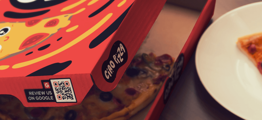 Uma caixa de pizza com um QR Code na lateral.