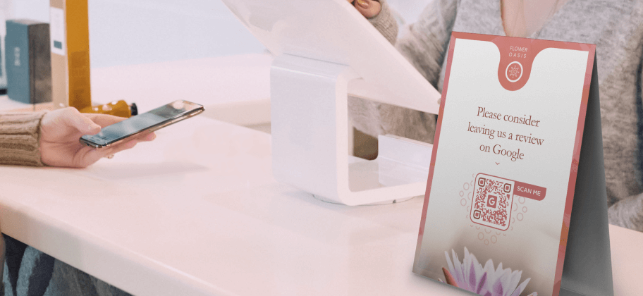 Um display de mesa na recepção de um estúdio de bem-estar com um QR Code Avaliações do Google